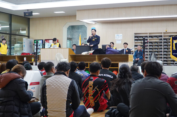 윤병태 나주시장이 무대 위에 올라 연설하고 있고, 많은 관람객들이 바닥에 앉아 연설자를 바라보고 있는 볼링장 내부 전경