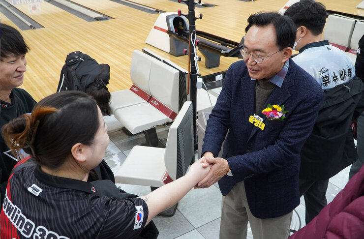 윤병태 나주시장이 볼링복을 입은 여성 선수와 악수를 나누고 있다.