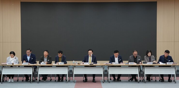 길게 이어진 테이블에 여러 명의 남녀가 앉아 회의하는 모습. 정면에 앉은 사람들은 각자 앞에 명패를 두고 있으며, 중앙에는 '시장' 명패를 둔 남성(나주시장 윤병태)이 앉아있다. 뒤쪽으로는 큰 검은색 스크린이 보인다.