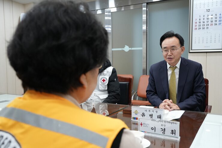 윤병태 나주시장이 회의 테이블 맞은편에 앉은 사람을 바라보며 대화하고 있는 모습