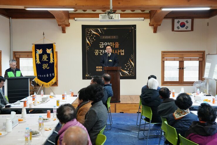 '금안마을 공간재생사업' 행사에서 윤병태 나주시장이 연단에서 발표하는 전경. 한옥 느낌의 넓은 공간에서 많은 주민들이 참석하여 발표를 듣고 있다.