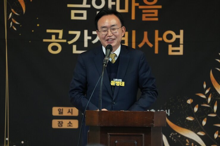  단상에서 발언하고 있는 윤병태 나주시장. 단상에 '나주시장 윤병태'라고 적힌 명패가 붙어 있으며, 배경에는 '금안마을 공간재생사업' 현수막이 걸려 있다.