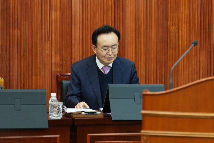  윤병태 나주시장이 회의장에서 앉아 태블릿 화면을 내려다보는 클로즈업 사진