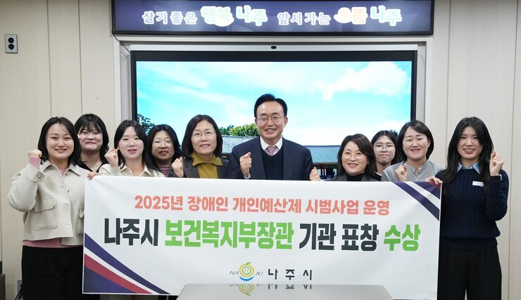  나주시 공무원들(중간 나주시장 윤병태)이 '2025년 장애인 개인예산제 시범사업 운영 나주시 보건복지부장관 기관 표창 수상' 현수막을 들고 단체 사진을 찍는 모습