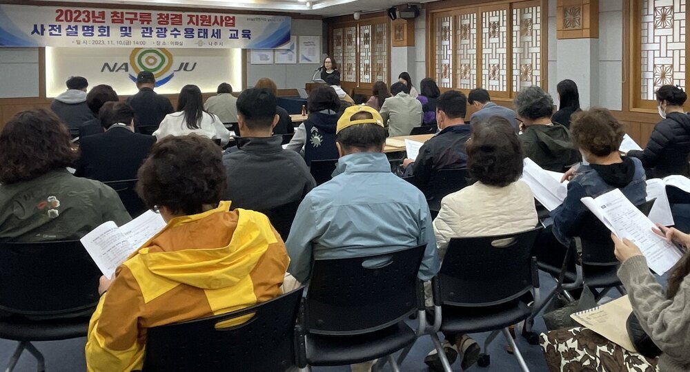 사업 사전설명회와 관광수용태세 교육장면을 찍은 사진이다 숙박업소 관계자들이 의자에 앉아 공무원이 하는 교육을 듣고 있다.