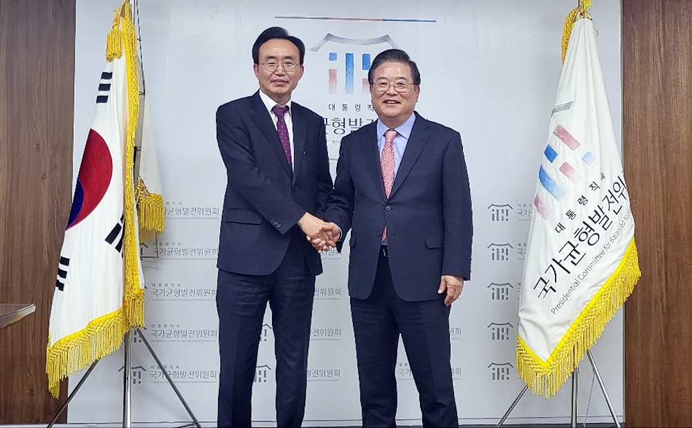 윤병태 나주시장이  우동기 국가균형발전위원장과 악수를 하는 모습