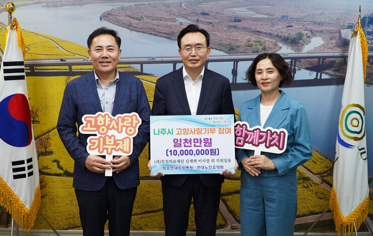 나주시 고향사랑기부 참여 일천만원(10,000,000원) 팻말을 든 시장님과 고향사랑 기부제 팻말을 든 남성과 함께가치 팻말을 든 여성 세 명이 기념촬영 중이다.