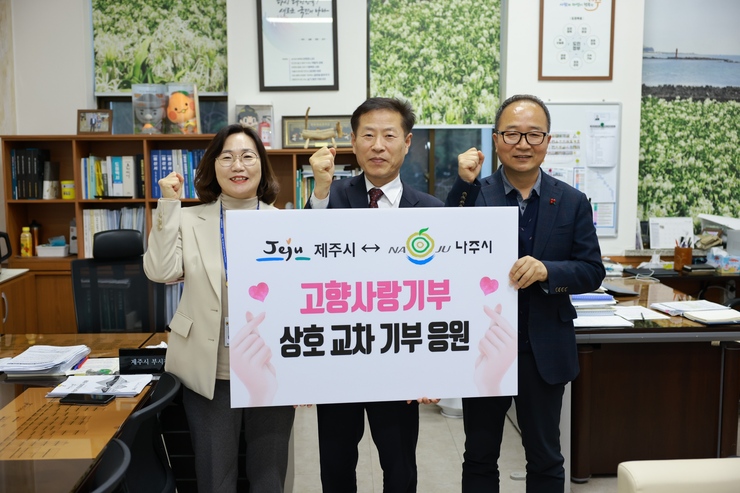 제주시-나주시 고향사랑기부 상호 교차 기부 응원 이라고 적힌 팻말을 들고 화이팅 포즈로 촬영하는 사진