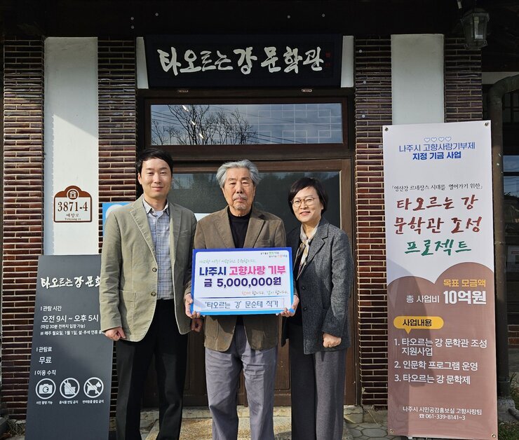 타오르는 강 문학관 3872-4 예향로 타오르는 강 문학관 |관람시간 오전 9시~오후5시(마감 30분 전까지 입장 가능) ※매주 월요일, 1월1일, 설,추석 연휴 휴관 |관람료 무료 |이용수칙 사진촬영가능 음식물 반입 금지 반려동물 출입 금지 라고 적힌 안내판. 나주시 고향사랑기부제 지정 지금 사업 「영산강 르네상스 시대를 열어가기 위한」타오르는 강 문학관 조성 프로젝트 목표 모금액 총 사업비 10억원 사업내용 1.타오르는 강 문학관 조성 지원사업 2.인문학 프로그램 운영 3.타오르는 강 문학제 나주시 시민공감홍보실 고향사랑팀 061-339-8141~3 현수막. 살기좋은 행복 나주 앞서가는 으뜸 나주 내고향 나주! 사랑하고 응원합니다. 나주시 고향사랑 기부 금 5,000,000원 함께 합니다. 같이 합니다. '타오르는 강' 문순태 작가 라고 적힘 팻말을 들고 있는 카키색 자켓을 입은 남성과 문순태 작가, 회색 자켓을 입고 안경을 끼고 있는 중년 여성