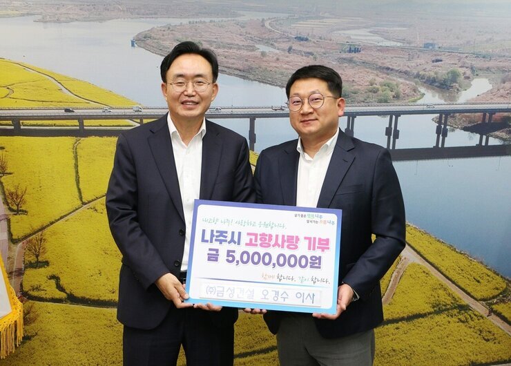 살기좋은 행복 나주 앞서가는 으뜸 나주 내고향 나주! 사랑하고 응원합니다. 나주시 고향사랑 기부 금 5,000,000원 함께 합니다. 같이 합니다. (주)금성건설 오경수 이사 라고 적힌 팻말을 들고 있는 윤병태 시장과 오경수 이사