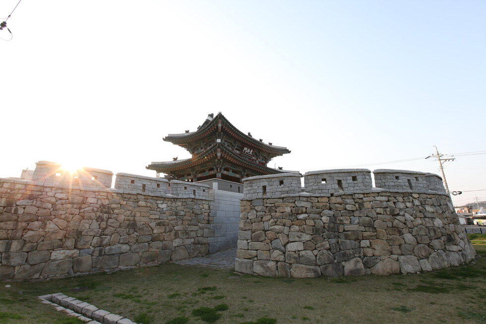 동점문 측면을 찍은 사진. 성벽이 보이고 그 뒤로 2층짜리 기와에 동점문이라는 현판이 걸려 있음.