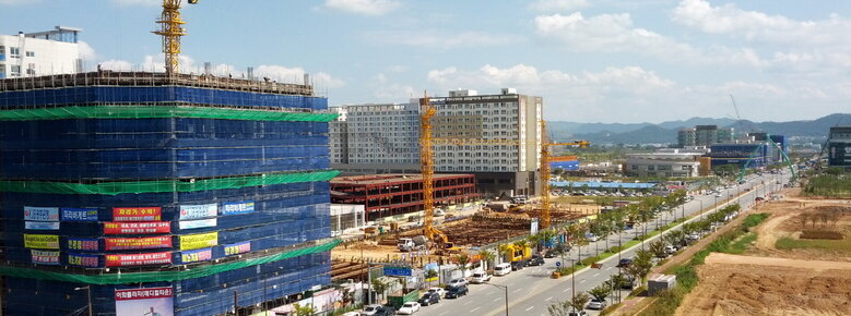 공사중인 건물들 뒤로 아파트단지가 보인다