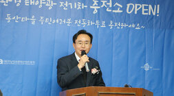 친환경 태양광 전기차 충전소 개소식에서 가슴에 꽃을 달고 마이크를 들고있는 나주시장의 모습