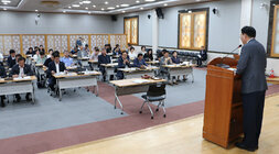 민주평화통일자문회의 정기회의 단상에서 인사말을 하고 있는 나주시장의 뒷편 측면에서 촬영한 모습 참석자들의 앉아 있는 앞모습도 보인다