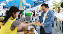 나주 빛가람 하이볼 페스티벌 나주시장이 행사장에 마련된 부스에서 오리날개 튀김을 판매자에게 선물로 받고 있는 모습