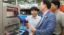 추석 명절 배 선과장 방문 나주시장이 켄베이어 의 당도 측정 기계 앞에서 관계자에게 설명을 듣고 있는 모습