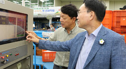 추석 명절 배 선과장 방문 나주시장과 관계자가 컨베이어 기계 앞에서 화면의 측정된 값을 한손으로 가리키며 대화를 나누는 모습