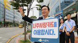 추석맞이 지역상품 판매 촉진 캠페인 및 청렴실천, 고향사랑 기부제 홍보 캠페인 나주시장이 얼굴에 미소를 지으며 나주사랑카드 이용 피켓을 들고 한손은 이동차량을 향해  손을 흔들며 홍보 캠페인을 하고 있는모습