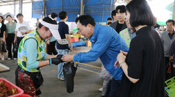 추석 명절맞이 영산포 풍물시장 장보기 행사 나주시장이 콩물을 판매하는 여성 상인에게 구입한 콩물을 건네받고 있는 모습