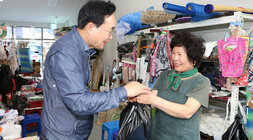 추석 명절맞이 세지5일장 장보기 행사 나주시장이 잡화점에서 양말을 구입하고 잡화점 여성 상인 분에게 물건을 받아 들고 있는 모습