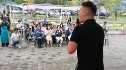 추석맞이 다문화가족 노래자랑 대학원에 진학한 외국 남학생의 노래하는 뒷편에서 촬영한 사진 나주시장과 배우자가 박수를 쳐주고 있는 앞모습과 참석자들이 박수를 쳐주고 있는 앞모습이 보인다