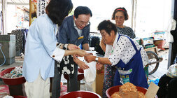 추석 명절맞이 나주목사고을시장 장보기 행사 나주시장과 배우자가 건어물을 판매하는 여성 어르신에게 물품을 구매하고 건네 받고 잇는 모습