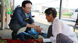 추석 명절맞이 나주목사고을시장 장보기 행사 나주시장이 쪼그려 앉아 목사고을시장 한쪽에서 나물을 판매하는 여성 어르신과 악수를 나누며 인사를 하고 있는 모습