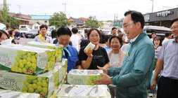 추석 명절맞이 공산5일시장 장보기 행사 나주시장이 샤인머스켓을 판매하는 여성 상인과 샤인머스켓 상자를 보며  웃고 잇는 모습