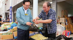 추석 명절맞이 공산5일시장 장보기 행사 나주시장이 콩나물을 판매하는 남성 상인분에게 콩나물을 구매하여 봉지에 담은 콩나물을 건네 받고 있는 모습