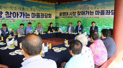 찾아가는 마을좌담회 마을 우산각에 마을 어르신들이 둘러 앉아 있고 나주시장이 여성 어르신의 이야기를 듣고 있는 모습