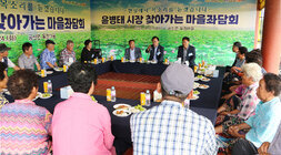 찾아가는 마을좌담회 나주시장이 여성 어르신을 손으로 가리키며 답변을 하고 있는 모습 우산각에 둘러 앉은 어르신들의 모습