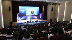 나주 글로벌에너지포럼 2024 시민특강 좌측면에서 촬영한 나주시장의 인사말 모습과 참석자들이 강연장에 앉아 있는 뒷모습