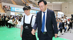 2024 전라남도 장애인 일자리 박람회 나주시장이 미소를 지으며 여자 장애인 소녀의 손을 잡고 무대 위로 올라가고 있는 모습