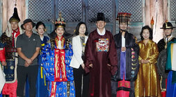 나주 문화유산 야행 나주시장이 관복을 입고 배우자와 관복을 입은 남, 여 관계자들과 금성관 바로 앞에 서서 기념촬영을 하고 있다