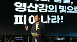 2024 나주영산강축제 개막식 영산강정원에 마련된 주무대 위에서 나주시장이 핀마이크를 귀에 걸고 개막식 환영사를 하고 있는 모습 한손을 들고 영산강 정원 조성에 때해 설명을 하고 있다