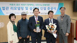 나주시노인복지관 별관 리모델링 준공식 나주시장과 나주시의회 의장이 각각 감상의 화분과 꽃다발을 받고 노인복지관장과 여성, 남성 어르신과 함께 기념촬영을 하고 잇는 모습