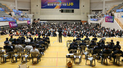 제17회 나주 페어컵 배드민턴 대축제 개회식 축사를 하고 있는 나주시장의 뒷편에서 촬영한 모습 참석 동호인들이 앉아 있는 모습 전면