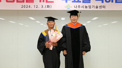 친환경농업대학 명품딸기반 수료식 나주시장과 공로패를 받은 수료생이 기념촬영을 하고 있는 모습