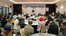 보훈가족 위로연 나주시장의 축사모습과 참석자들이 운형테이블에 앉아 있는 모습