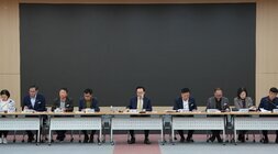 길게 이어진 테이블에 여러 명의 남녀가 앉아 회의하는 모습. 정면에 앉은 사람들은 각자 앞에 명패를 두고 있으며, 중앙에는 '시장' 명패를 둔 남성(나주시장 윤병태)이 앉아있다. 뒤쪽으로는 큰 검은색 스크린이 보인다.