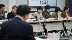 회의에 참석한 사람들이 테이블에 앉아 서류를 보거나 경청하고 있다. 테이블 앞에는 '송월동장', '봉황면장', '다도면장', '신포면장', '금천동장' 등 명패가 놓여 있다.