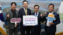 야외 풍경을 배경으로 네 명의 남성(가운데 나주시장 윤병태)이 서서 사진을 찍고 있다. 중앙의 두 남성은 '나주시 고향사랑 기부 금 10,000,000원'이 적힌 기부증서를 들고 있으며, 양쪽 끝의 남성들은 '나주사랑'과 '고향을 사랑하는 마음' 문구가 적힌 손팻말을 들고 있다. 모두 미소를 짓고 있다.