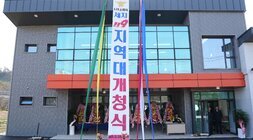 신축된 나주소방서 세지 119 지역대 건물 외관. 깔끔한 회색 외벽에 주황색 포인트가 들어간 2층 건물이며, 정면에는 세로로 길게 '나주소방서 세지 119 지역대 개청식' 현수막이 걸려있다. 건물 주변에는 화환들이 놓여있다.