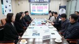 회의 또는 간담회 장면. 직사각형 테이블에 마주 앉은 나주시 관계자들과 기업 관계자들이 대화를 나누고 있다. 테이블 위에는 '조광호', '서영고', '나상채' 등의 명패가 놓여 있으며, 뒤쪽 화면에는 '나주시 일반산단 입주기업협의회 성금·후원물품 기탁 (300만원) (930만원 상당)'이라는 문구가 보인다.