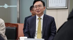  나주시장 명패가 놓인 테이블에 앉아 미소를 짓고 있는 윤병태 나주시장의 클로즈업 사진.