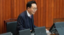 윤병태 나주시장이 회의장에서 앉아 태블릿 화면을 내려다보는 클로즈업 사진