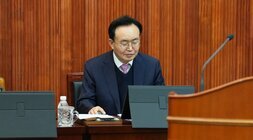 윤병태 나주시장이 회의장에서 앉아 태블릿 화면을 내려다보는 클로즈업 사진