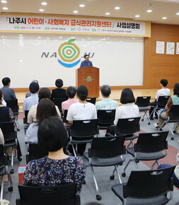 나주시 어린이 사회복지 급식관리지원센터 사업설명회 나주시장의 인사말 모습과 참석자들이 앉아 있는 뒷모습 전면