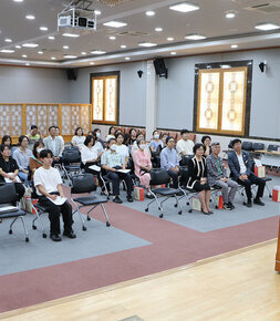 나주시 어린이 사회복지 급식관리지원센터 사업설명회 인사말을 하고 있는 나주시장의 뒷편에서 촬영한 사진 참석자들이 앉아서 듣고 있는 모습이 보인다
