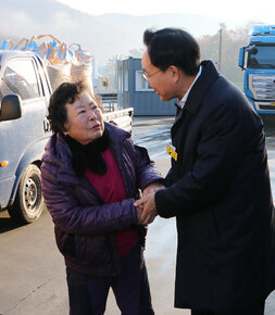 다도면 DSC 수매현장 방문 나주시장이 현장을 방문하여 여성 농민분과 두손을 맞잡으며 대화를 나누는 모습